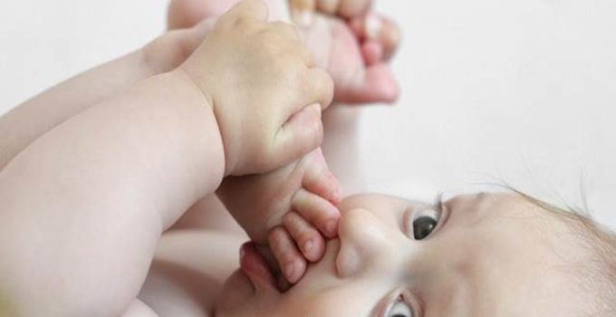 Baby beißt sich in den Fuß
